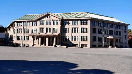 Three-story government building with green flat commercial roof, ideal for storm damage restoration.