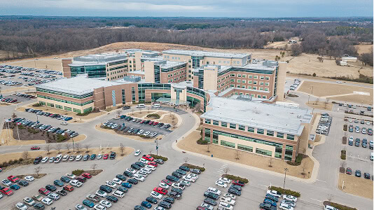 Aerial view of a hospital complex with flat roofs, ideal for commercial roofing and large-loss restoration.