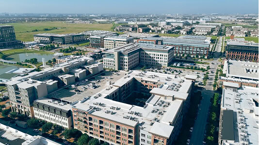Aerial view of a commercial complex with flat roofs, reroofing, and storm restoration work.