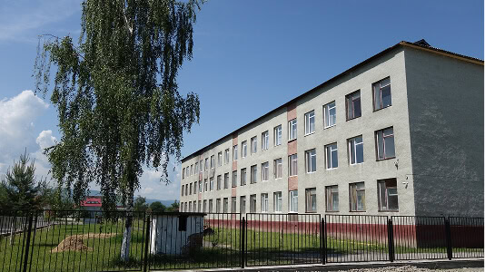 A three-story commercial building with flat roof, ideal for commercial roofing and storm damage restoration.