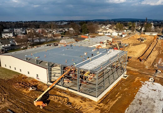 Aerial view of commercial roofing project with steel frame, machinery, and large-loss restoration.