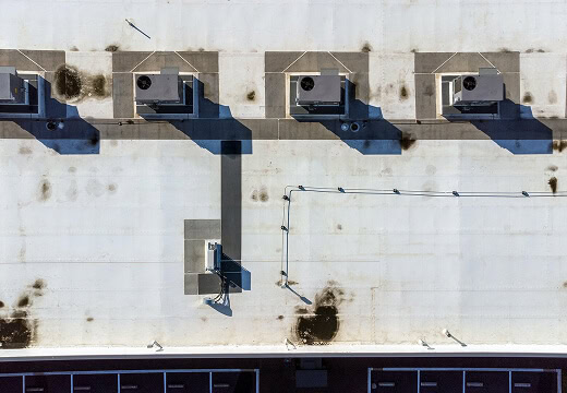 Aerial view of a commercial flat roof with HVAC units, ideal for large-loss recovery and reroofing.