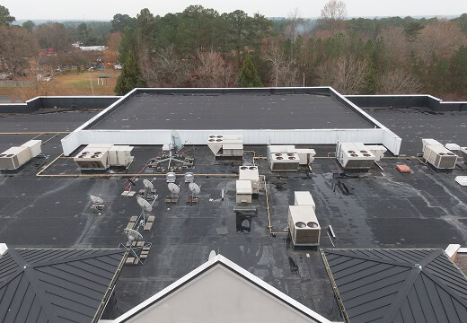 Flat commercial roofing with HVAC units, ideal for large-loss restoration and storm damage recovery.