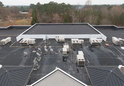 Flat commercial roofing with HVAC units, ideal for large-loss restoration and storm damage recovery.