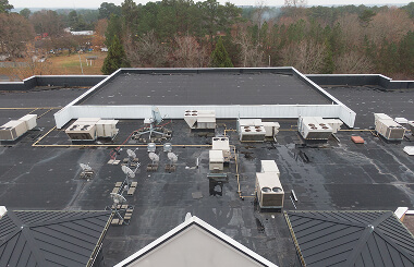 Flat commercial roofing with HVAC units and ductwork, ideal for large-loss restoration.